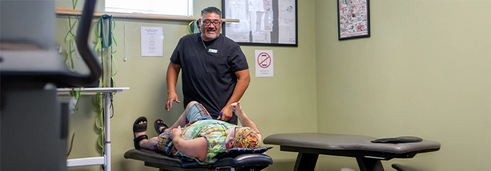 Chiropractic San Antonio TX Man Receiving Phycial Rehabilitation Therapy Man Lying Down Receiving Phycial Rehabilitation Therapy